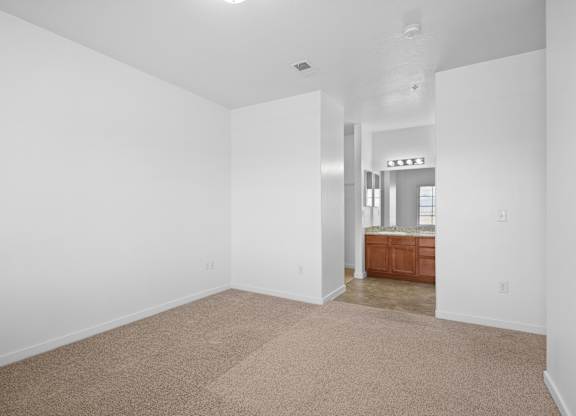 A large empty room with a carpeted floor and white walls.