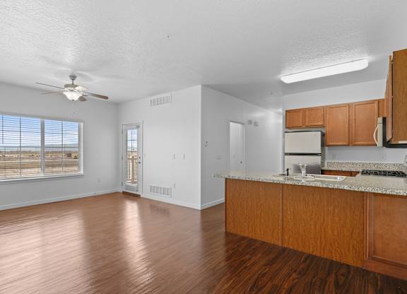 A kitchen with wooden cabinets and a marble countertop.