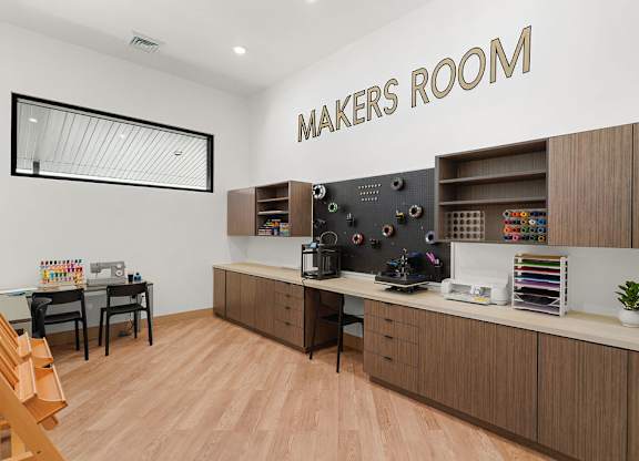 A makers room with a wooden floor and a white wall.