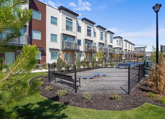 a fenced in play area with a pool in front of a building