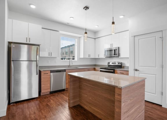 an updated kitchen with stainless steel appliances and white cabinets