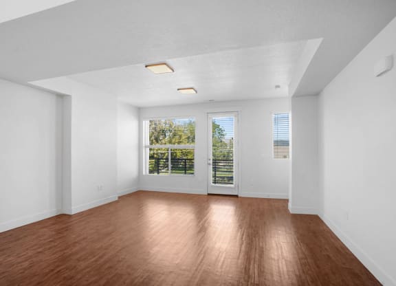 an empty living room with white walls and wood floors