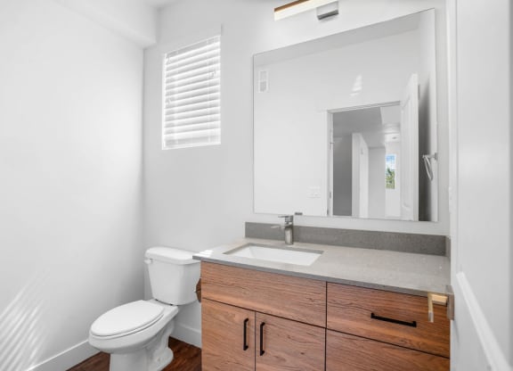 a bathroom with a toilet sink and a mirror