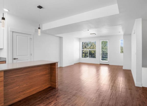an empty living room with white walls and wood floors