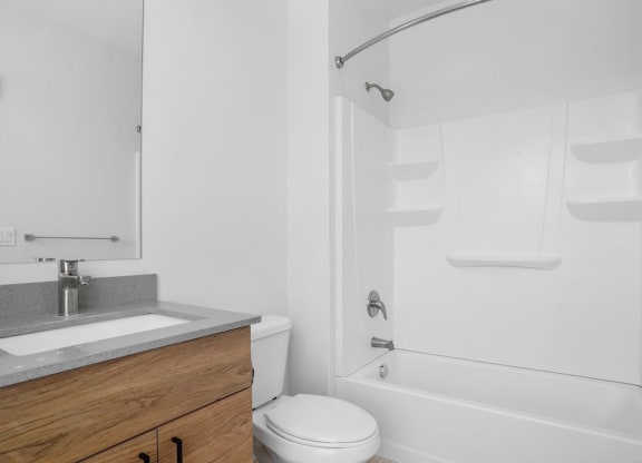 a white bathroom with a shower and a sink