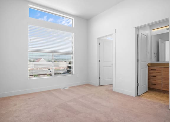 a bedroom with a large window and a closet