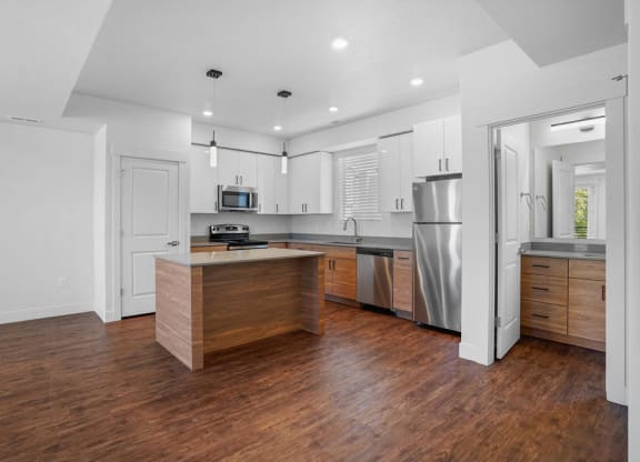 a kitchen with a large island and a stainless steel refrigerator