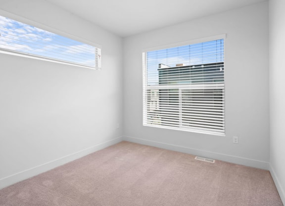 an empty room with a large window with blinds