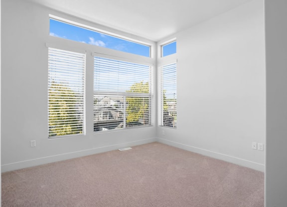 an empty room with white walls and windows