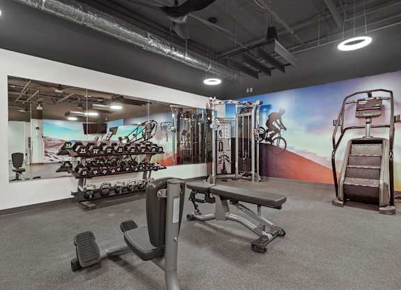 A gym with a variety of equipment including weights and a treadmill.