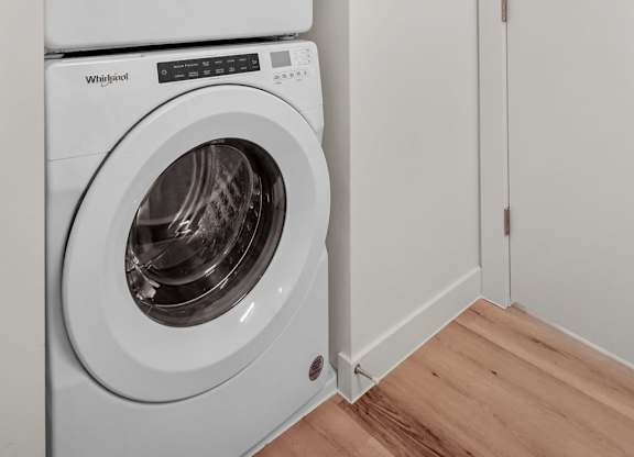 Two white washing machines stacked on top of each other.