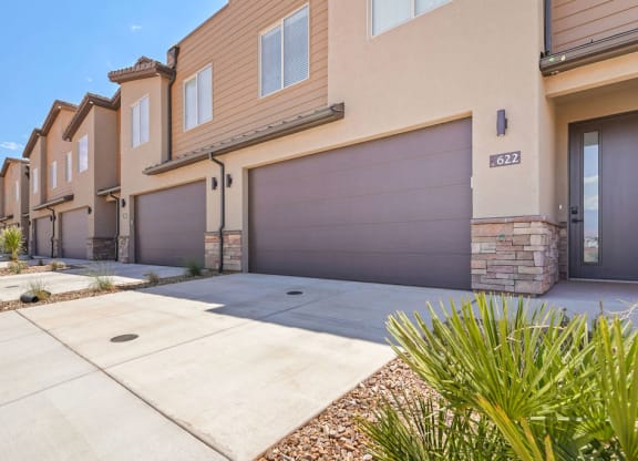 a sidewalk in front of a house with a garage door