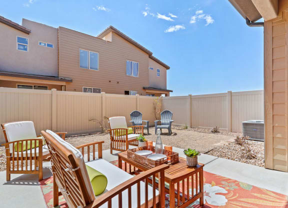 a patio with a table and chairs in front of a house