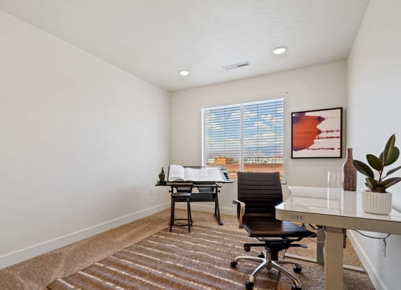 an office with a desk and chair and a window