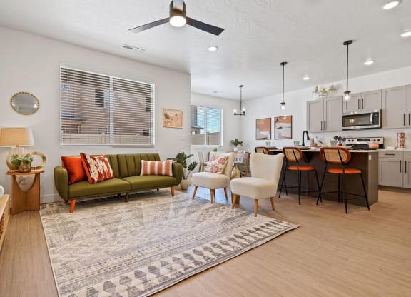 a living room and kitchen with a couch and chairs