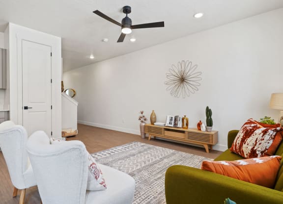 a living room with furniture and a ceiling fan