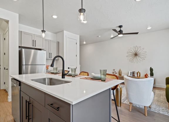 an open kitchen and dining area with a stainless steel refrigerator
