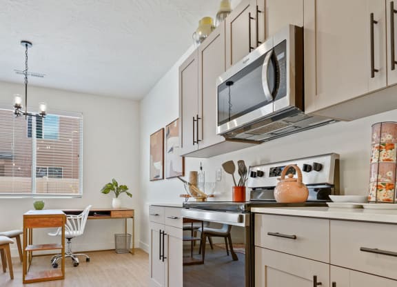 a kitchen with white cabinets and appliances and a table with chairs