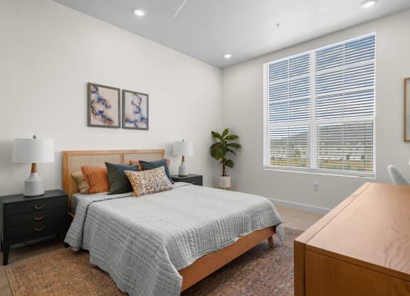 a furnished bedroom with a large window