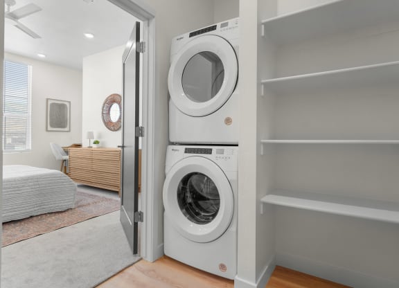 a laundry room with stacked washer and dryer