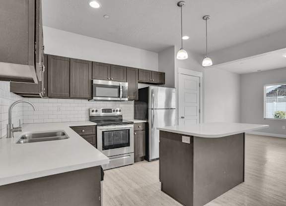 A modern kitchen with stainless steel appliances and wooden cabinets.