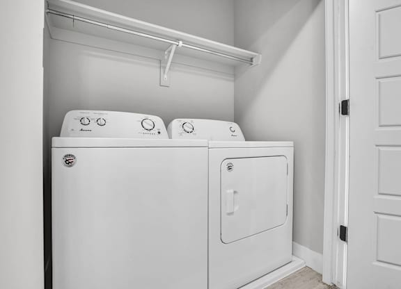 A white washing machine and dryer in a small laundry room.