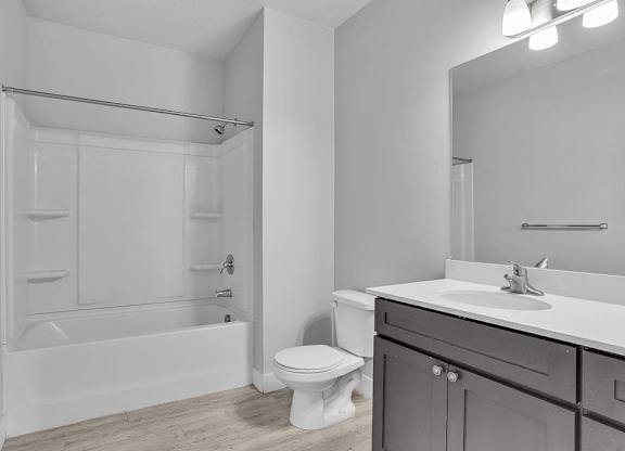 A white bathroom with a toilet, sink, and bathtub.