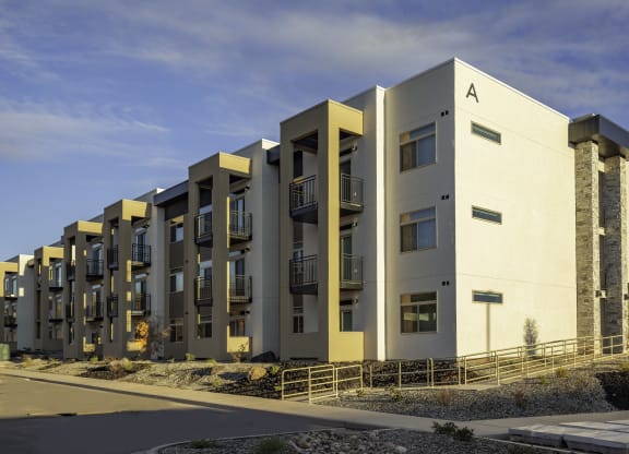 a row of modern apartments with balconies and a sky background