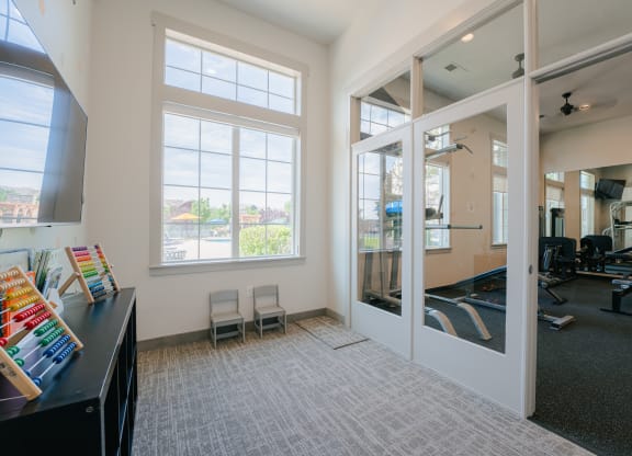 an office with large windows and a desk with chairs at Aldara Apartments in Saratoga Springs, Utah
