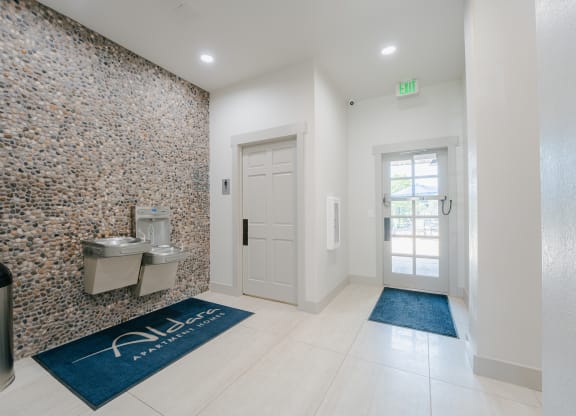 a bathroom with a urinal and a sink and a door at Aldara Apartments in Saratoga Springs, Utah