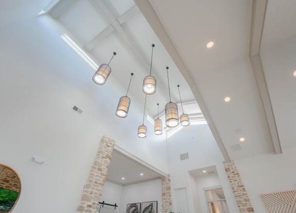 high ceilings and lights in a living room with a brick wall at Aldara Apartments in Saratoga Springs, Utah
