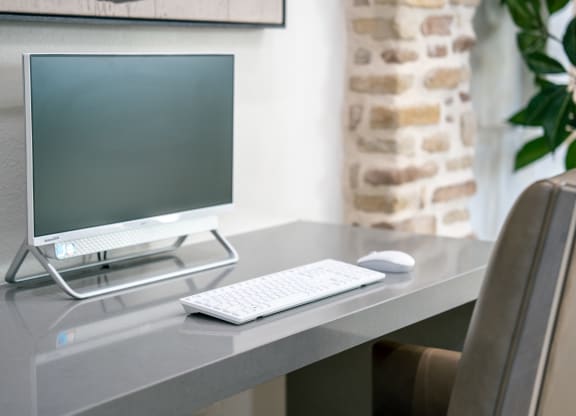 a desk with a computer monitor and a keyboard and mouse at Aldara Apartments in Saratoga Springs, Utah