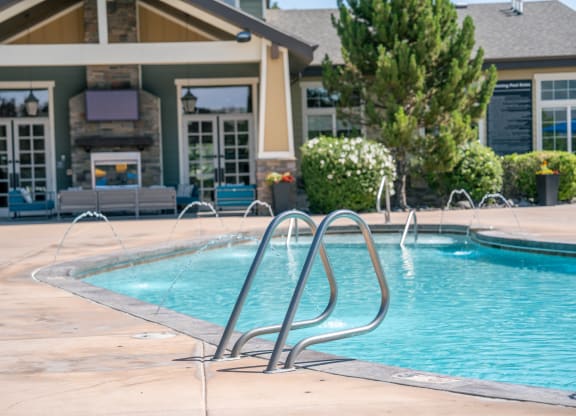 a swimming pool with water fountains in front of a house at Aldara Apartments in Saratoga Springs, Utah