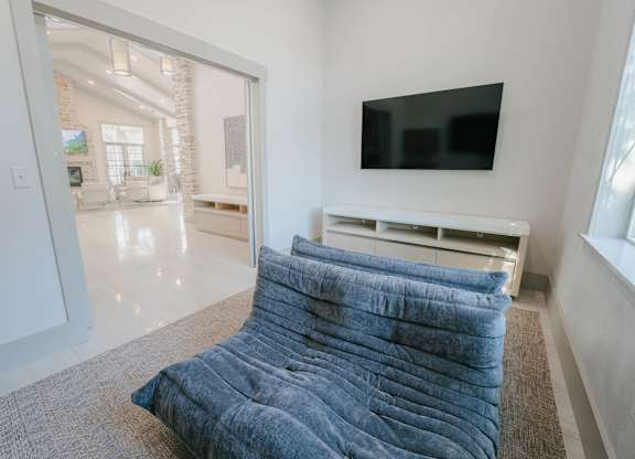 A blue comforter is on a bed in a white room.