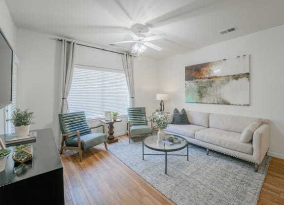 a living room with a couch and chairs and a ceiling fan at Aldara Apartments in Saratoga Springs, Utah