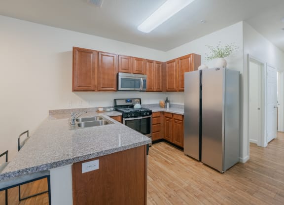 a kitchen with stainless steel appliances and a granite counter top at Aldara Apartments in Saratoga Springs, Utah