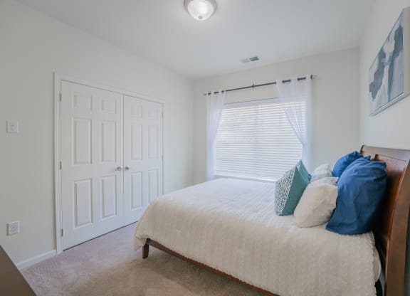 an empty bedroom with a bed and a window at Aldara Apartments in Saratoga Springs, Utah