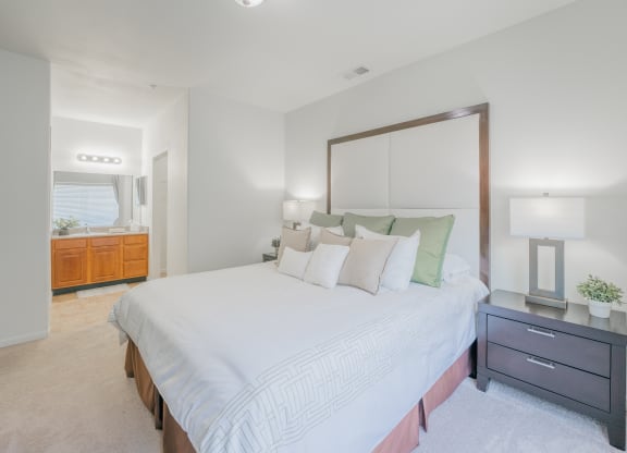 a bedroom with a large white bed and a mirror at Aldara Apartments in Saratoga Springs, Utah