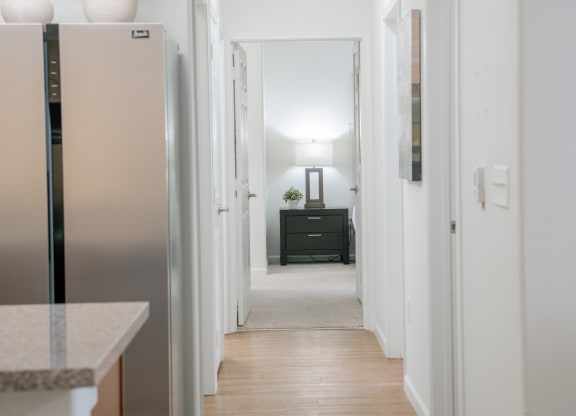 a view of a hallway in a home with a refrigerator and a black dresser at Aldara Apartments in Saratoga Springs, Utah