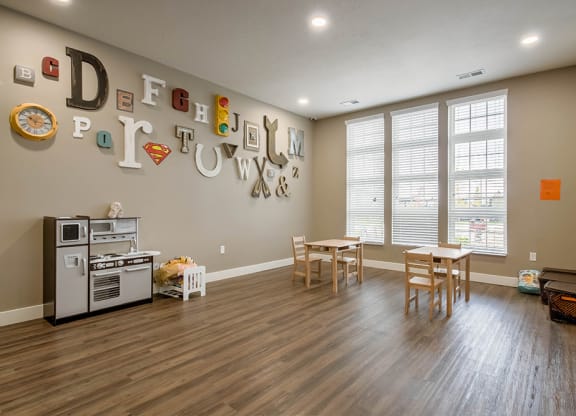a playroom with a table and chairs and a stove