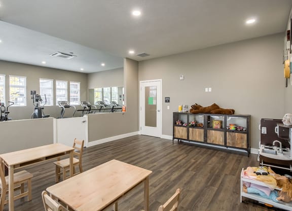 a fitness room with a table and chairs and a treadmill