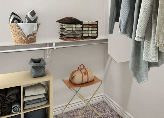a walk in closet with shelves and a rack of clothes