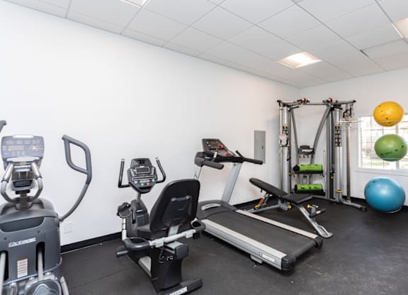 A gym with a treadmill, exercise bike, and other equipment.