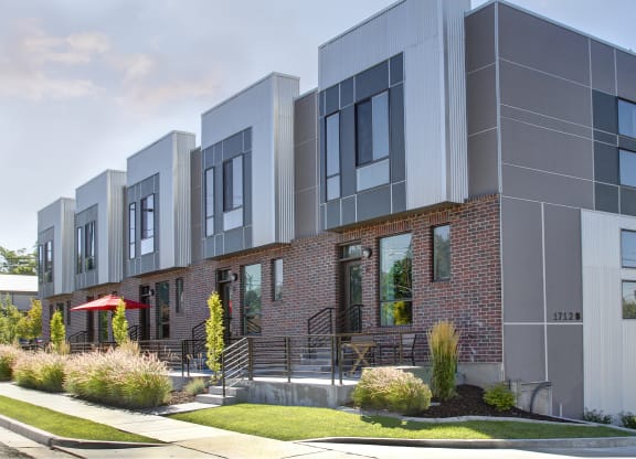 a row of apartments with a sidewalk in front of them at BlueKoi Townhomes for rent in Salt Lake City, UT