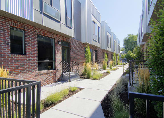 a sidewalk in front of a brick apartment building at BlueKoi Townhomes for rent in Salt Lake City, UT