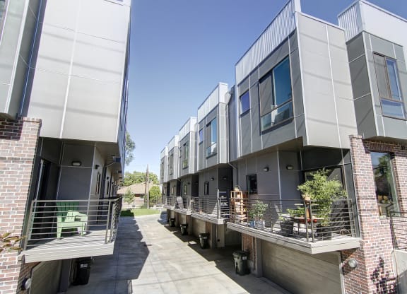 a row of modern apartments with balconies and a sidewalk at BlueKoi Townhomes for rent in Salt Lake City, UT