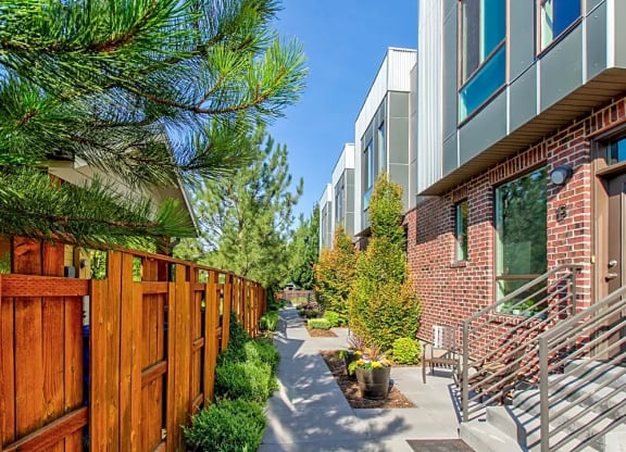 a patio with chairs and a wooden fence next to a brick building  at BlueKoi Townhomes for rent in Salt Lake City, UT