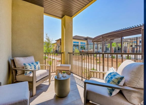 a balcony with a couch and chairs and a beautiful view at Brookfield Apartments for rent in St. George, UT.