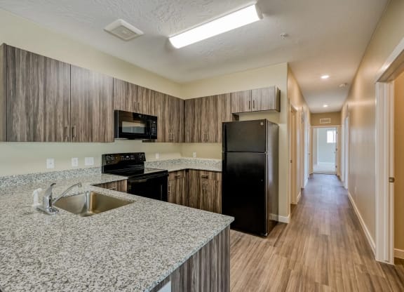 a large kitchen with a sink and a refrigerator at Brookfield Apartments for rent in St. George, UT.