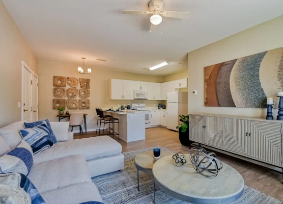 a modern living room and kitchen with a couch and a table at Brookfield Apartments for rent in St. George, UT.